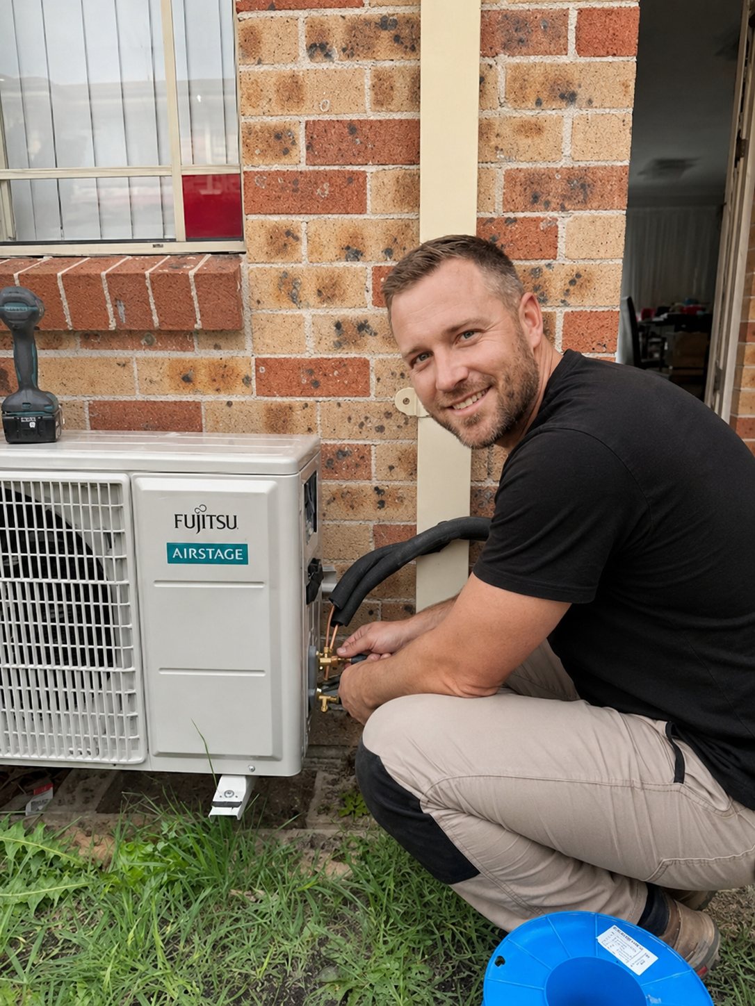 Technician connecting refrigerant lines to a Fujitsu Airstage outdoor unit